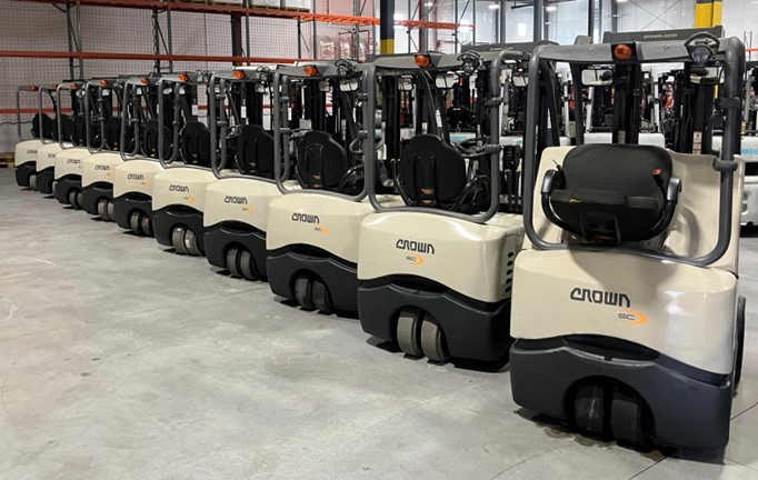 Crown electric forklifts lined up inside a warehouse