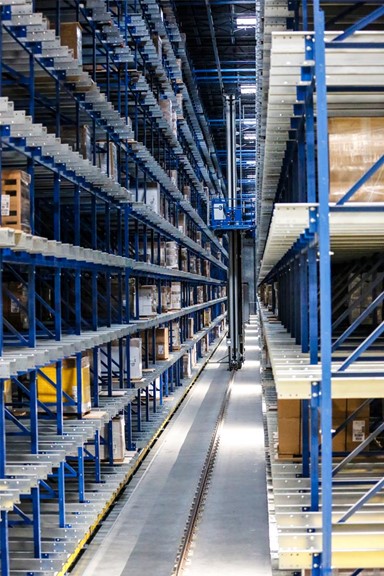 Large warehouse aisle with tall blue metal shelving units