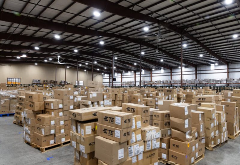 Warehouse filled with stacked cardboard boxes on pallets under high metal racks in Tennessee and Kentucky