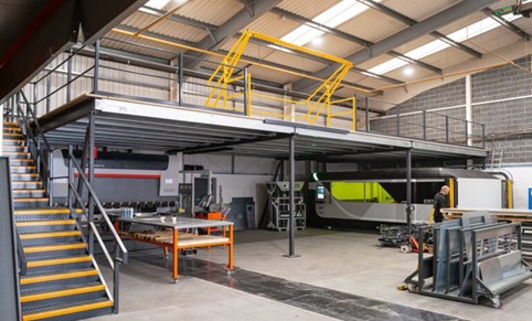 Bailey Industrial Mezzanine Platform with Yellow Stairs Inside Warehouse.