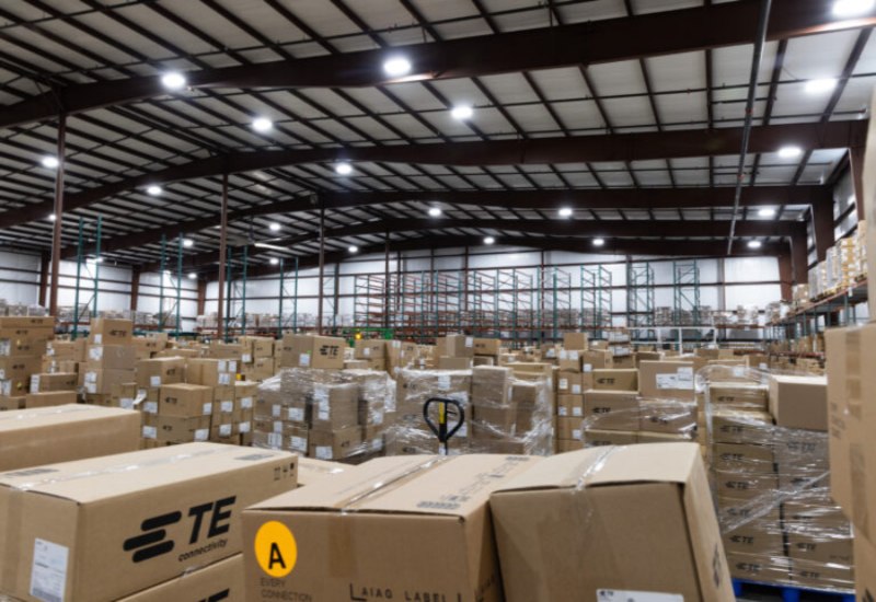 Large warehouse interior with stacked cardboard boxes and empty metal shelving in Tennessee and Kentucky